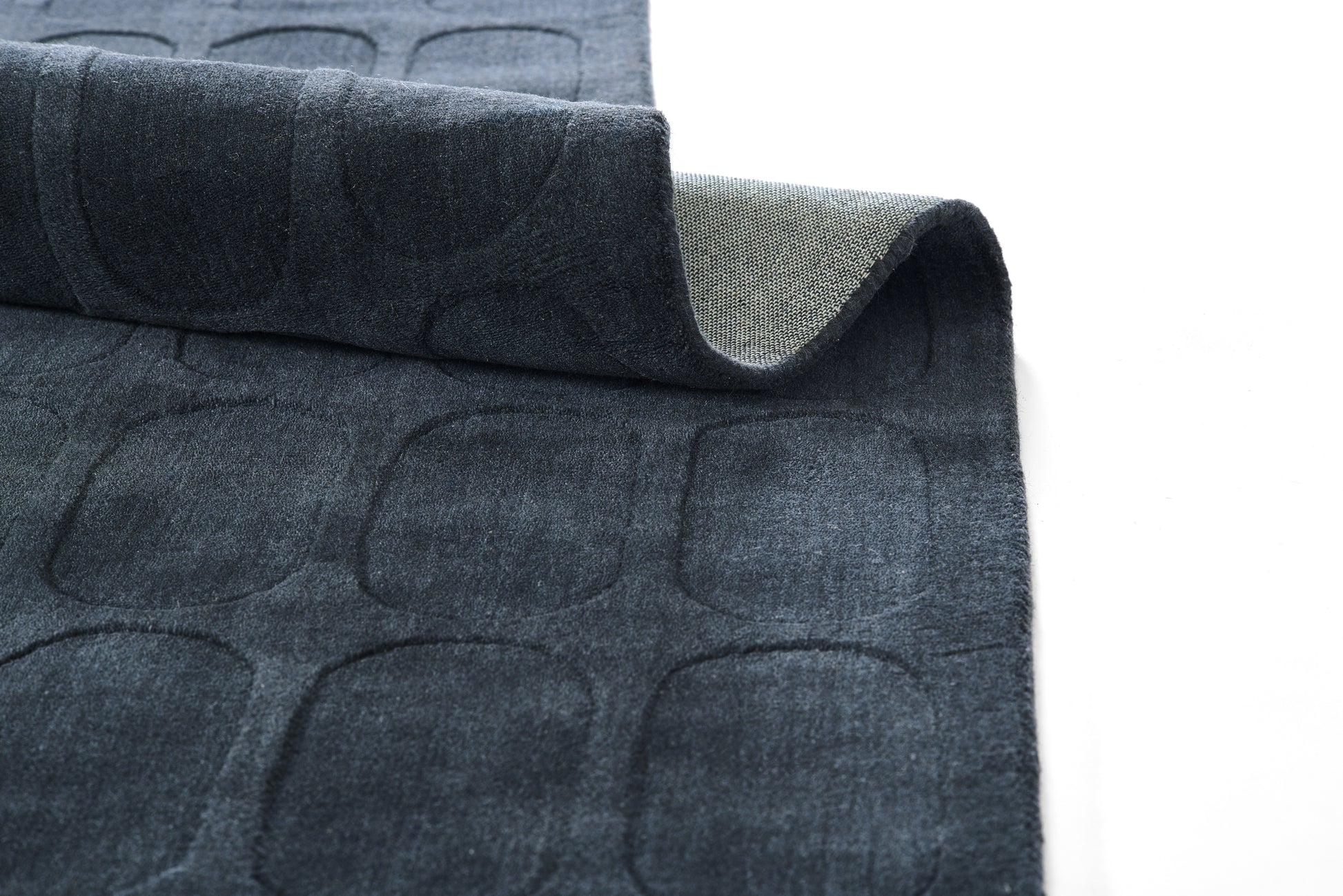 Dark navy quilted rug with rounded rectangle pattern; soft velvety top and beige reverse.