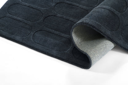 Navy blue anti-slip floor mat with embossed oval pattern, gray underside visible at rolled edge.