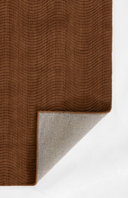 Brown textured rug with subtle wavy rib pattern; folded corner reveals light gray underside.
