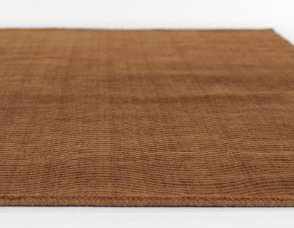 Brown rectangular rug with corduroy-like ribbed texture and clean finished edges.