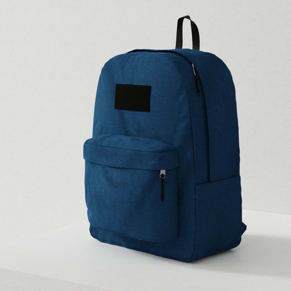 Blue textured fabric bag with a black patch, front zip pocket, top handle, and side pocket.