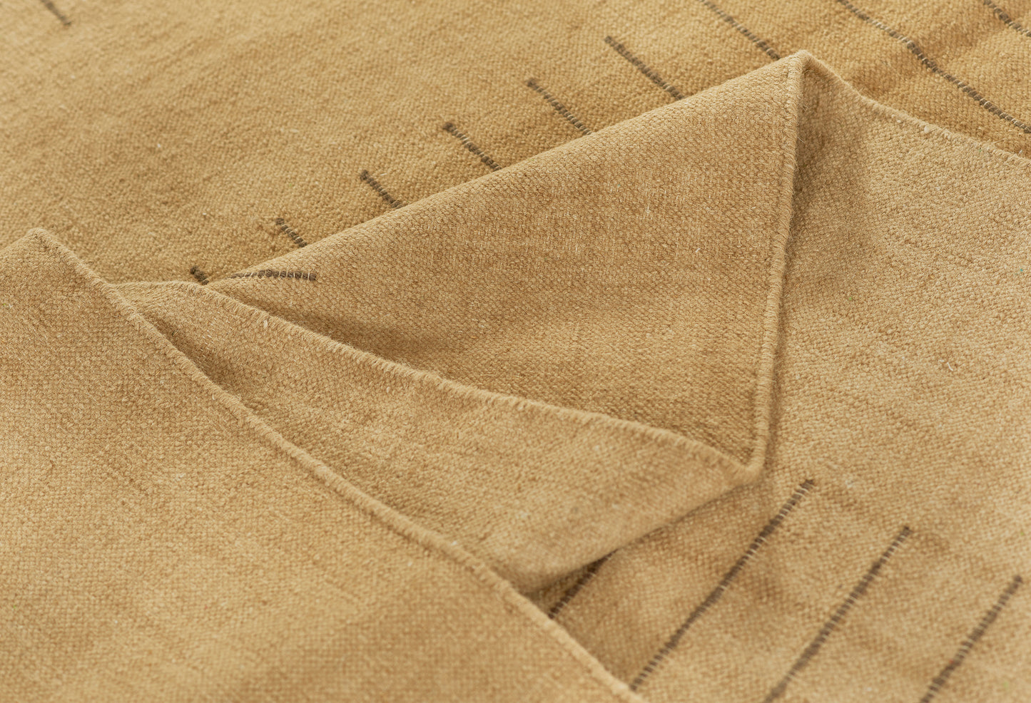 Beige woven textile with a folded corner, soft cotton-linen feel and subtle dark stripes.