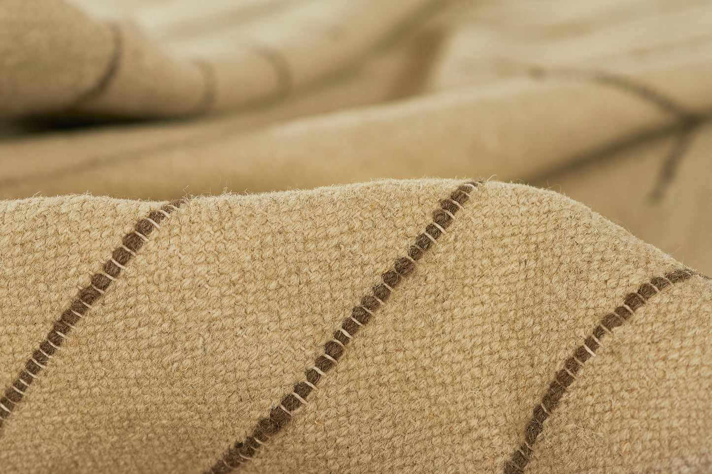 Beige textured woven fabric with dark brown diagonal stripes; cozy throw/blanket material.
