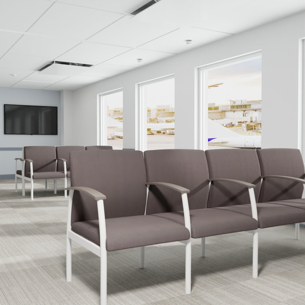 Modern waiting room with rows of gray chairs upholstered in charcoal solid crepe fabric on white frames, large windows, and a wall-mounted TV.