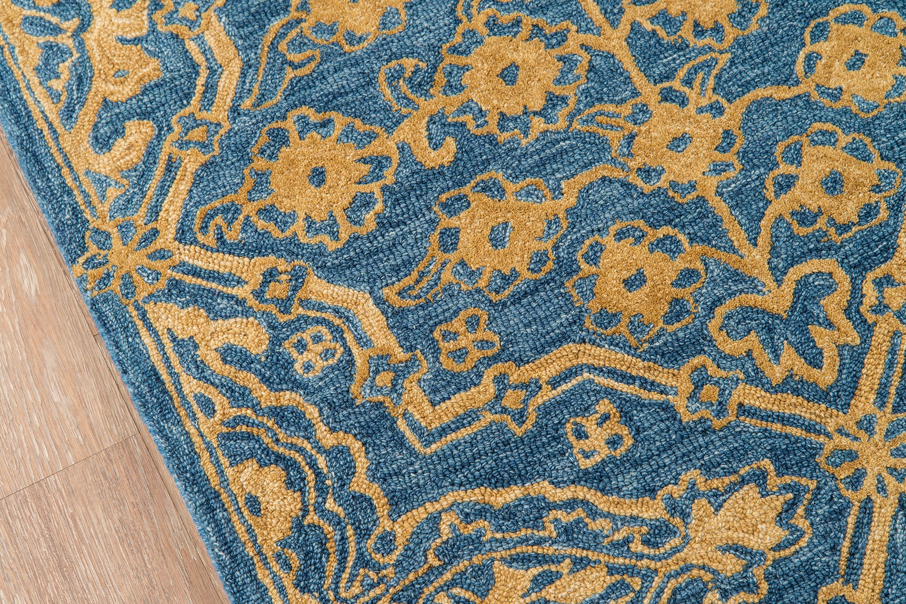 Blue area rug with gold floral motif, woven texture, traditional oriental-inspired style for living room.