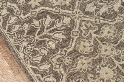 Brown and beige floral patterned area rug on wooden floor.