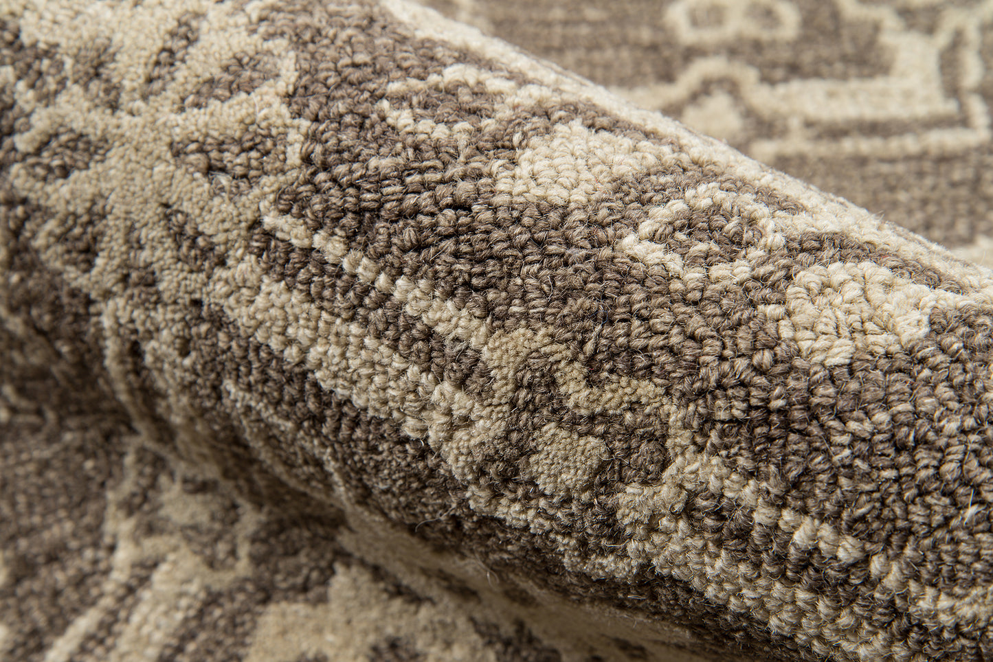 Brown and beige tufted rug with plush pile and geometric motifs, Persian-inspired.