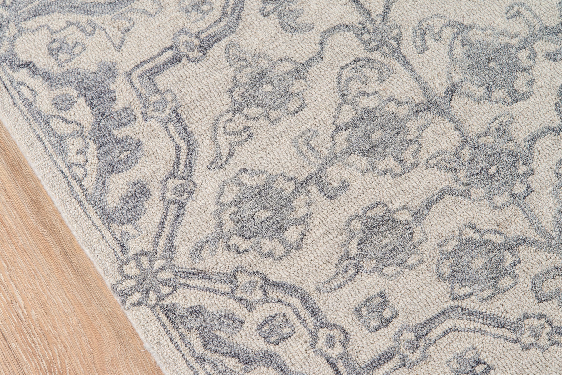 Rectangular gray damask rug on light ivory; soft woven texture, decorative living room accent.
