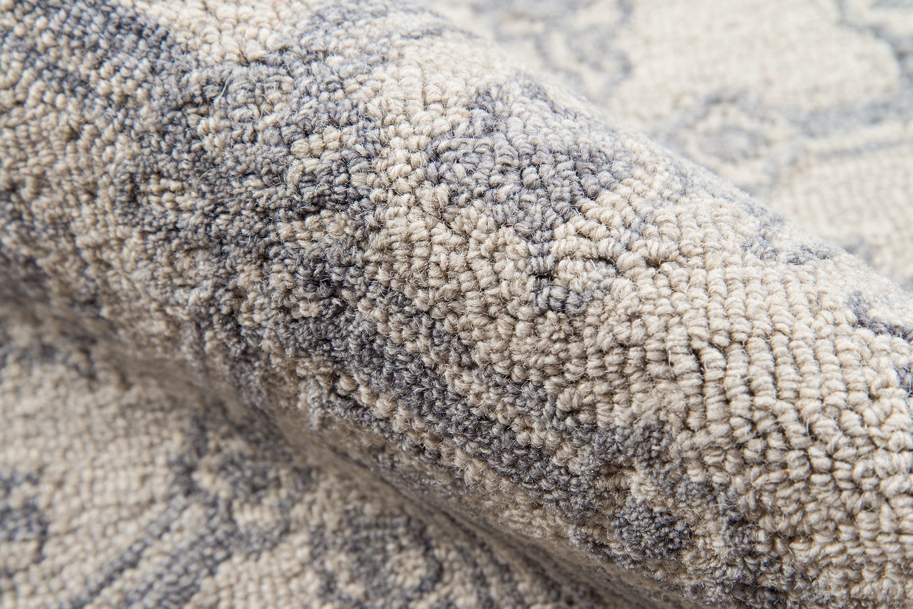 Close-up of a grey and beige textured shag rug with loop pile, cozy home decor.