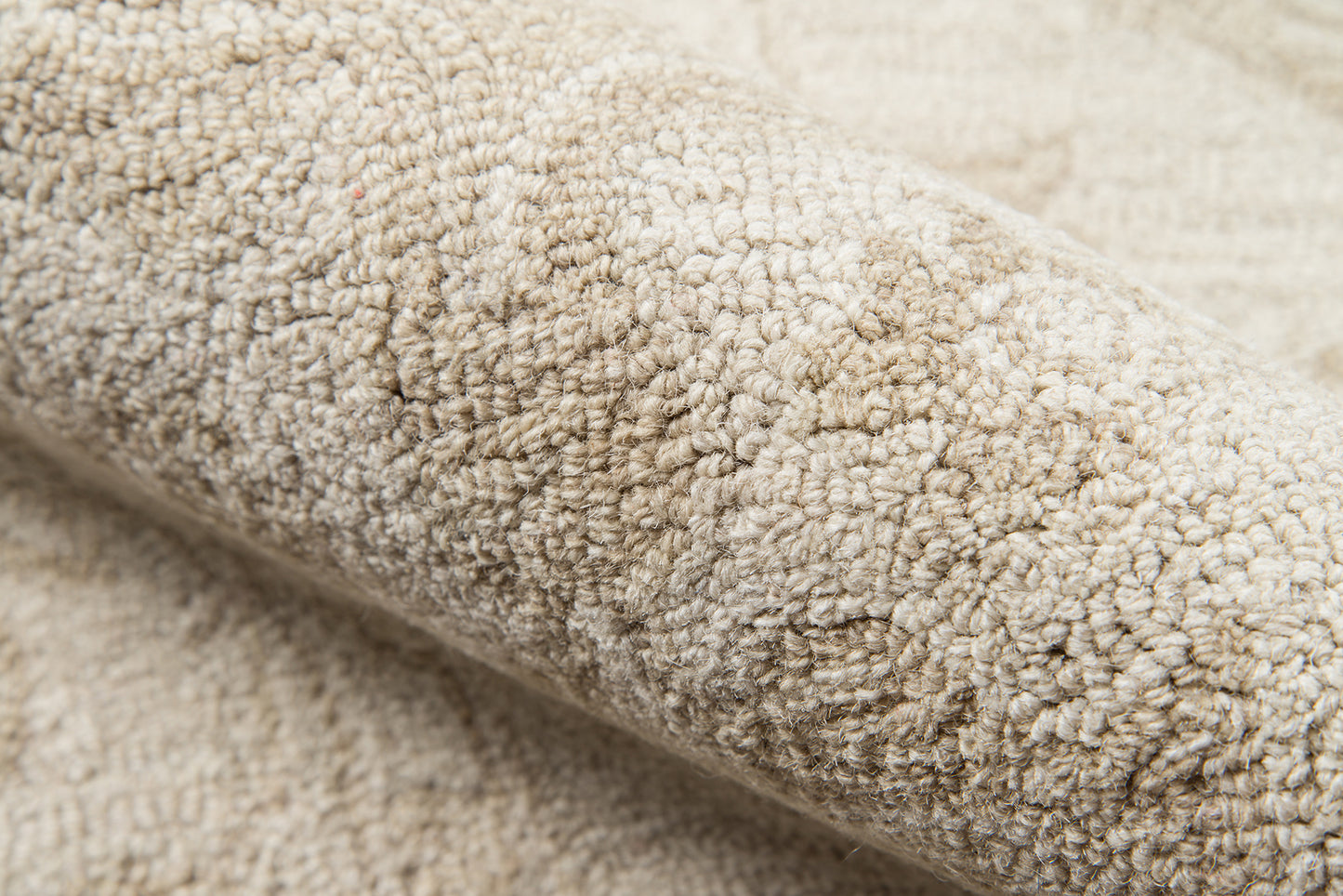Beige textured shag carpet close-up, soft loop-pile rug.