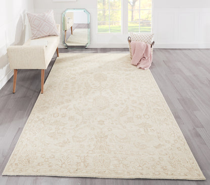 Cream ornate rug runner on gray wood floor; pale pink throw, cream sofa, turquoise-framed mirror, sunlit living room.