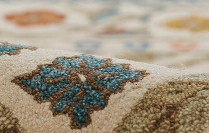 Close-up of a beige wool rug with blue and brown floral medallion, plush textured pile, rustic Persian-inspired design.