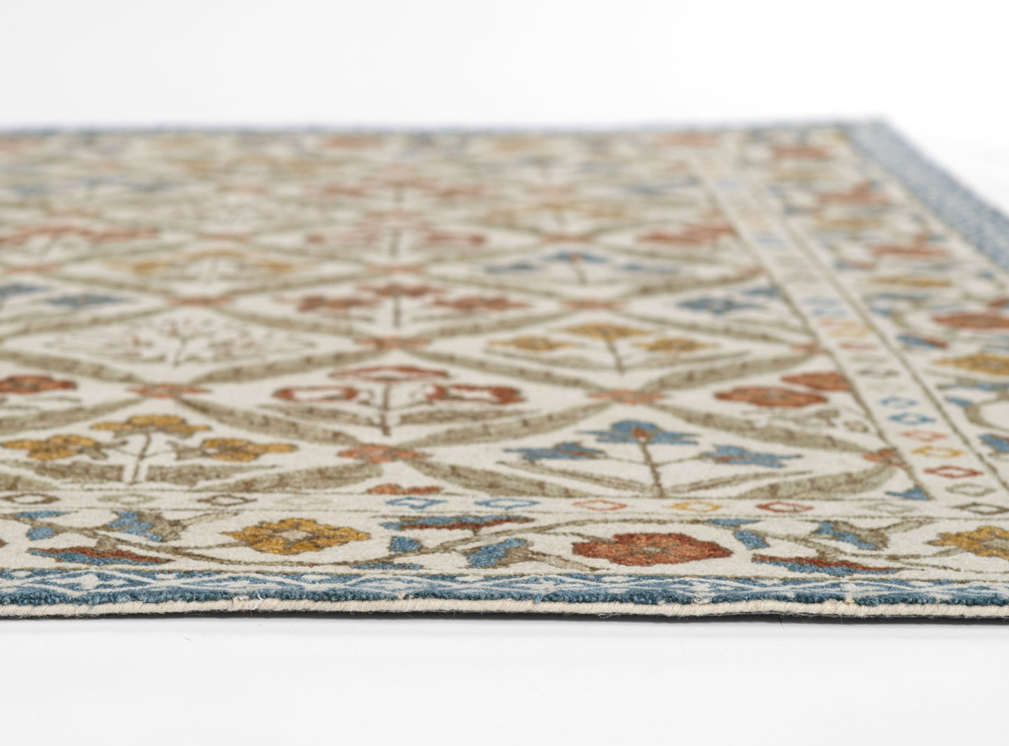 Cream cotton rug with blue border; rectangular, geometric floral pattern in rust, blue and olive, low-pile.