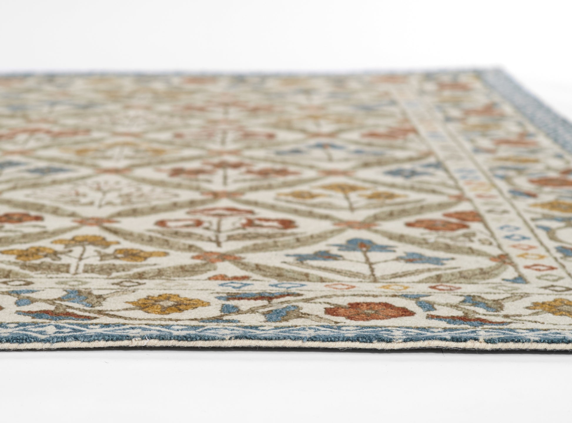 Beige oriental rug with blue border and multicolor floral lattice; close-up corner view.