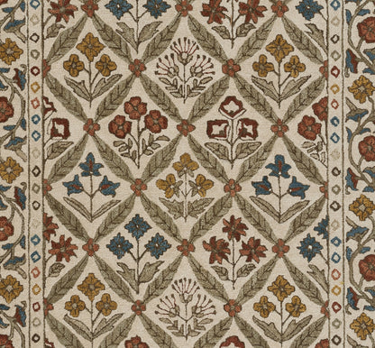 Traditional Cotswold-style woven rug with diamond lattice and colorful floral motifs in beige, rust, blue, and mustard.