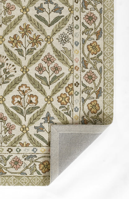 Rectangular traditional floral rug with green lattice vines and pastel blossoms, beige border; folded corner shows gray backing.