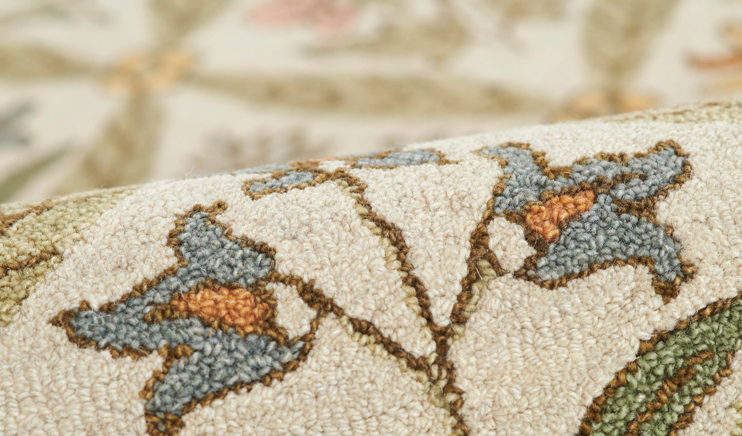 Beige textured woven fabric with blue-gray floral motifs and orange centers; rustic decorative textile.