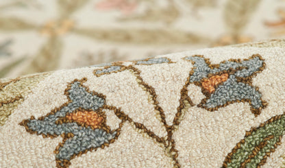 Beige textured woven fabric with blue-gray floral motifs and orange centers; rustic decorative textile.
