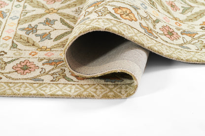 Soft cream Cotswold-style woven rug with pastel green, pink and blue floral pattern; rolled edge visible.