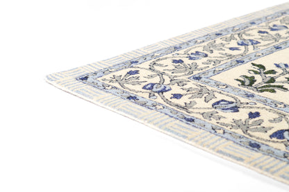 Cream rug with blue floral border & fringe edges, woven texture; Persian/Oriental style for living room decor.