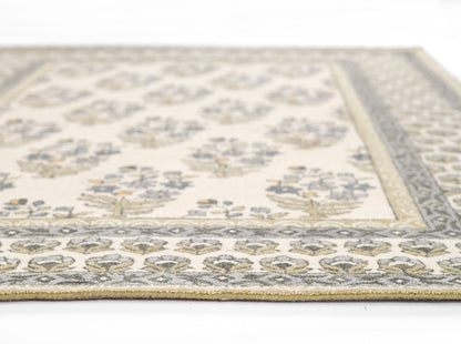 Cream area rug with blue-gray border and gold floral motifs; woven vintage-style living room rug.