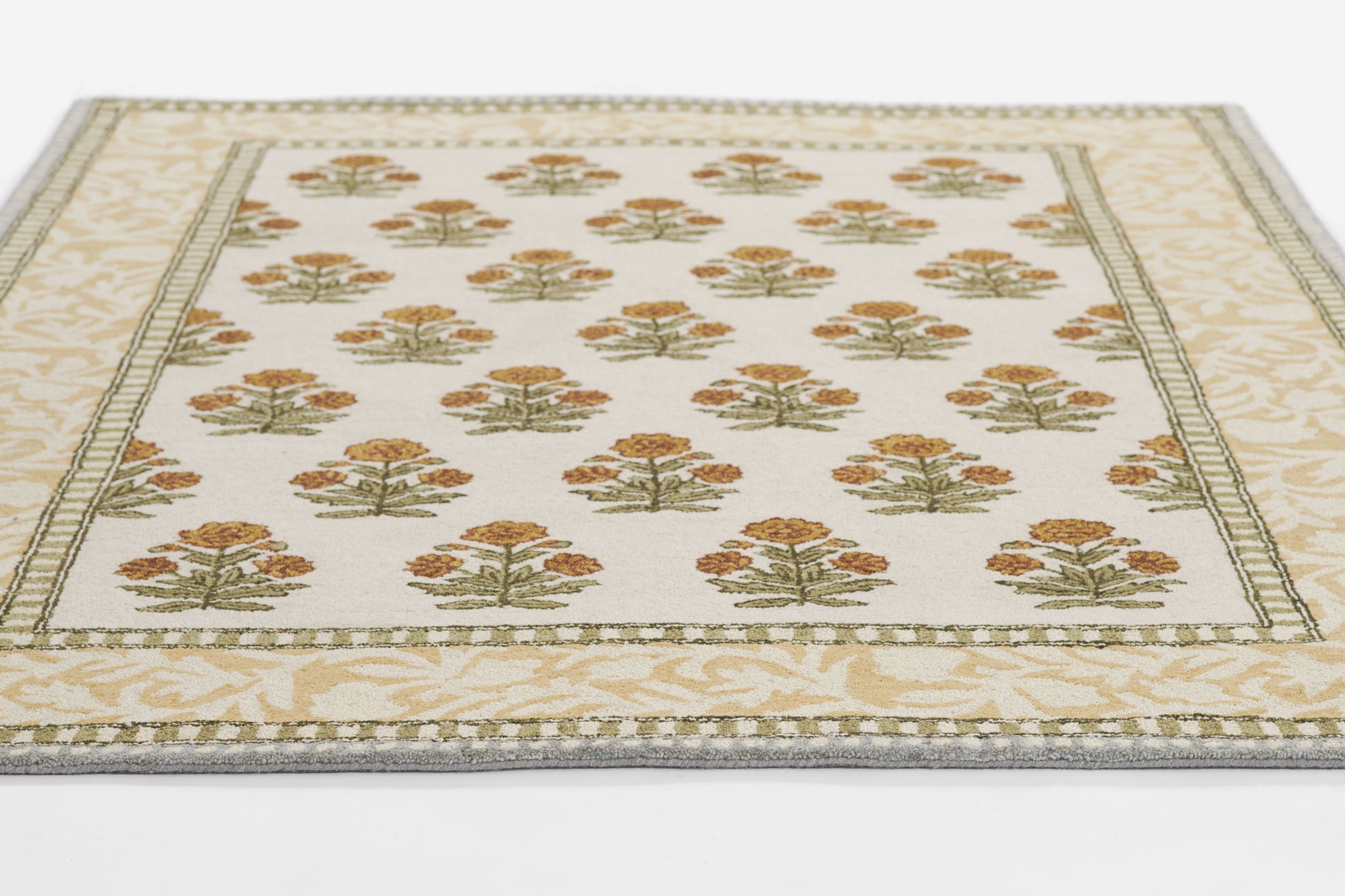 Rectangular cream runner rug with repeating orange-gold tree bouquets, green sprigs, and a pale beige decorative border.