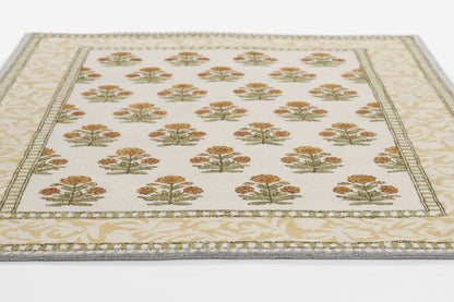 Rectangular cream runner rug with repeating orange-gold tree bouquets, green sprigs, and a pale beige decorative border.