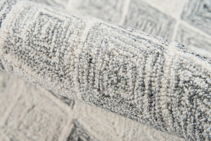 Rolled gray geometric rug with raised loop-pile texture for contemporary living spaces.