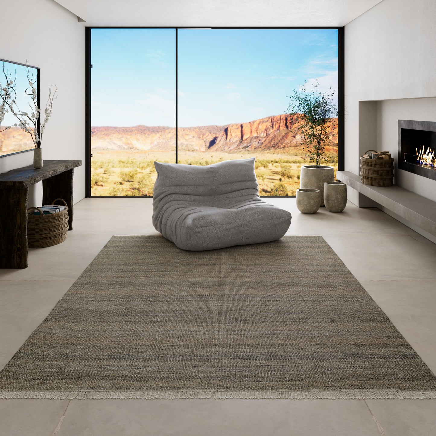 Gray Cove rug, 5' x 8' woven textured area rug with fringe edges in a minimalist living room with a gray bean bag and fireplace.