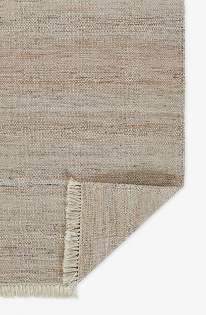 Natural beige woven rug with fringe along edges; rectangular jute-style texture for casual living spaces.