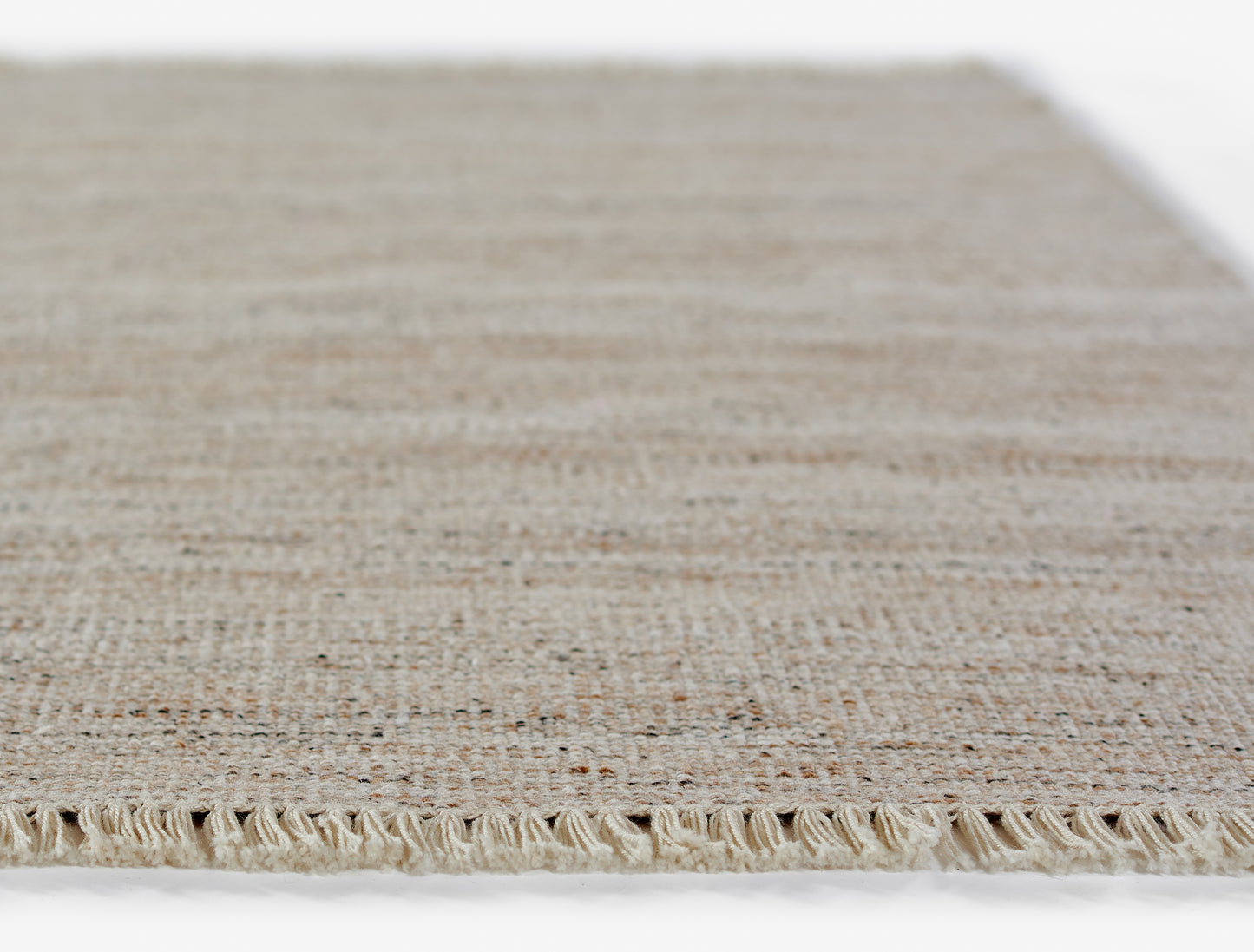 Natural beige woven jute rug with fringed edge and textured weave; rectangular area mat.