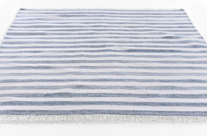 Blue and white striped rectangular rug with fringe, casual coastal flat-weave.