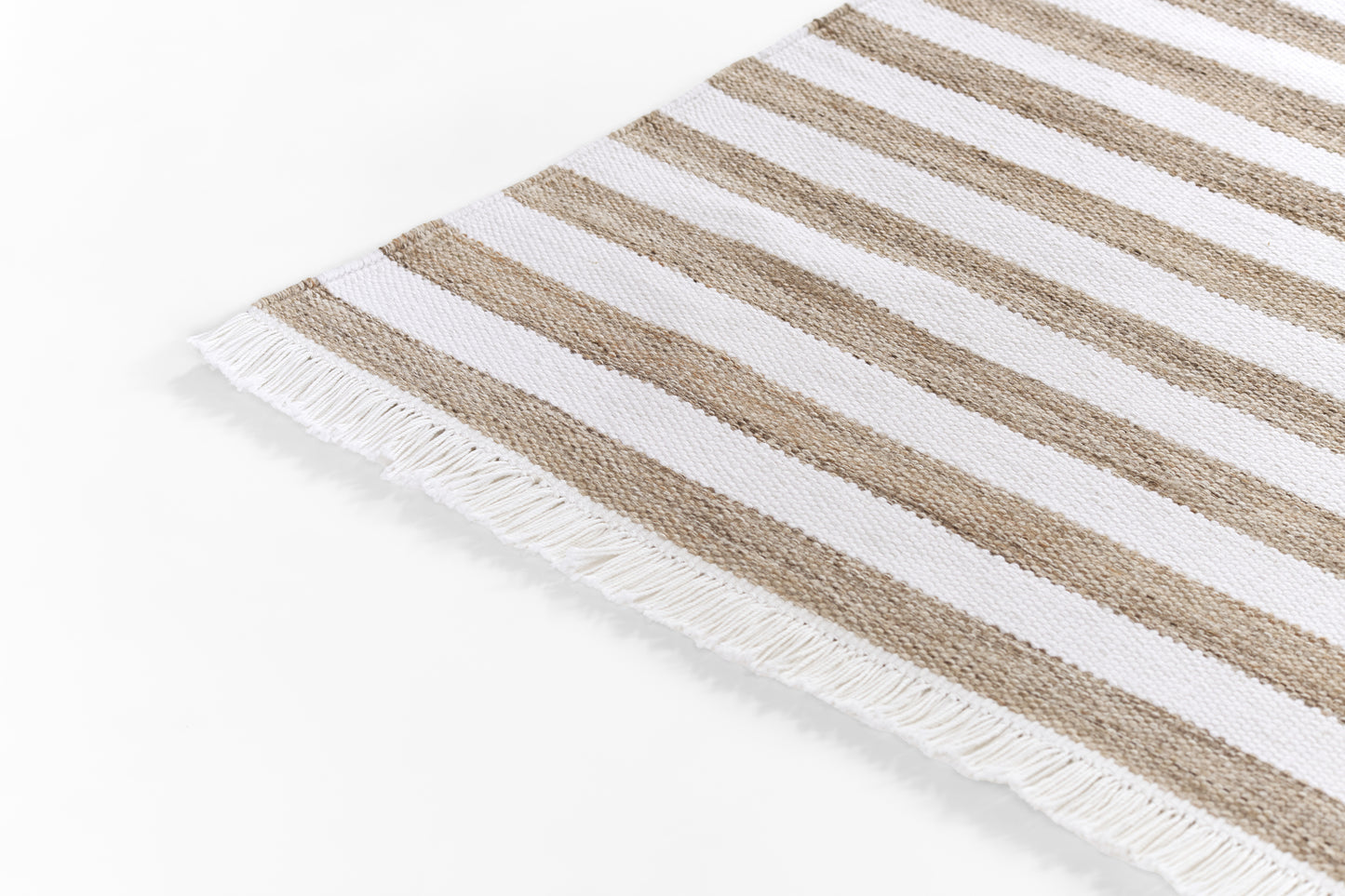 Beige and white striped woven rug with white fringe along edges, rectangular.