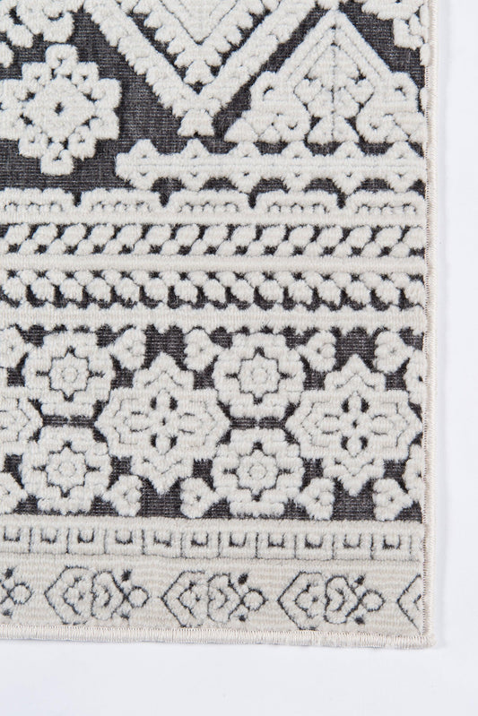 Rectangular runner rug with black base and cream embroidery of geometric floral rosettes and bordered bands, boho Moroccan style.