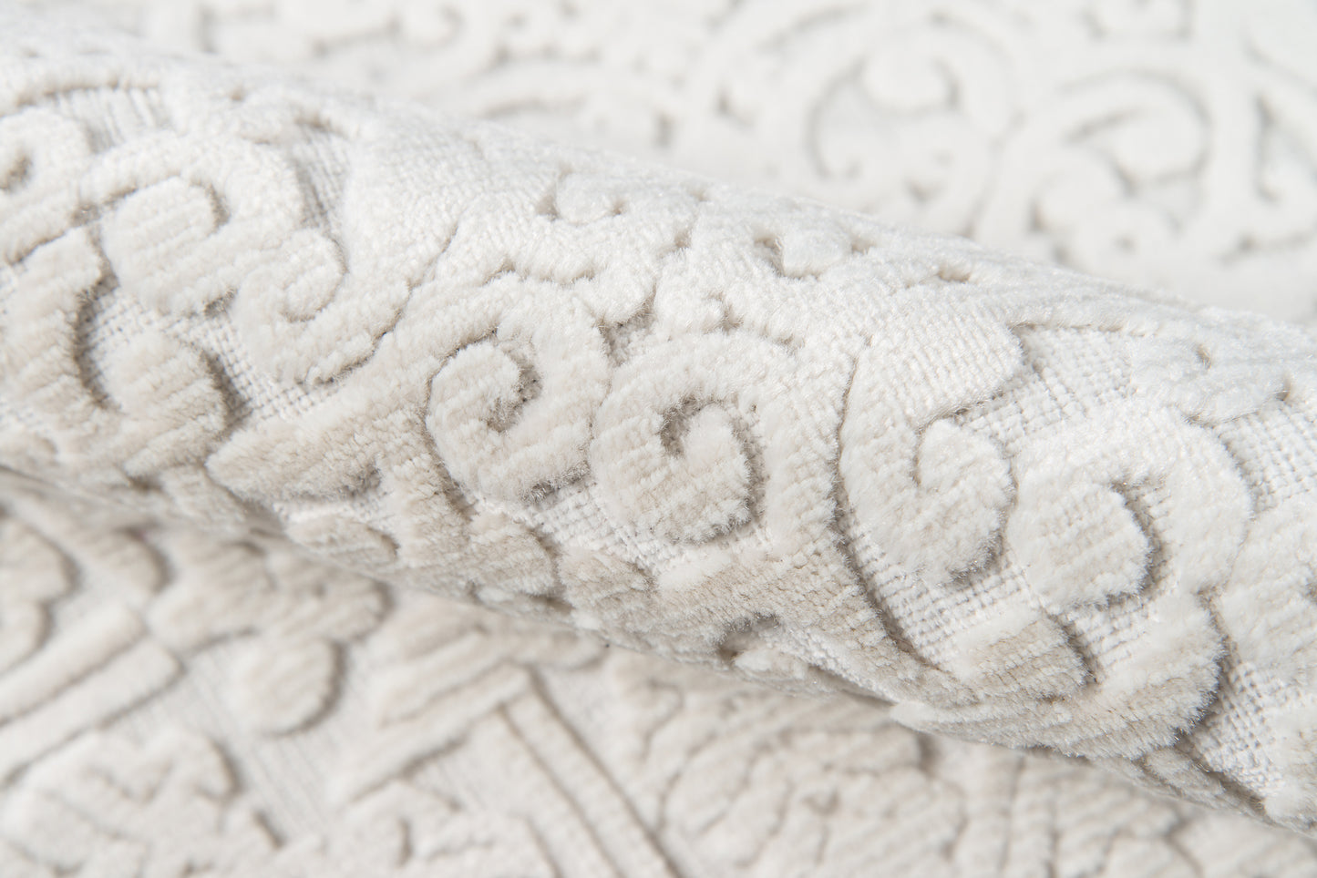 Ivory damask jacquard fabric with raised scrolling floral pattern, soft textured upholstery textile.