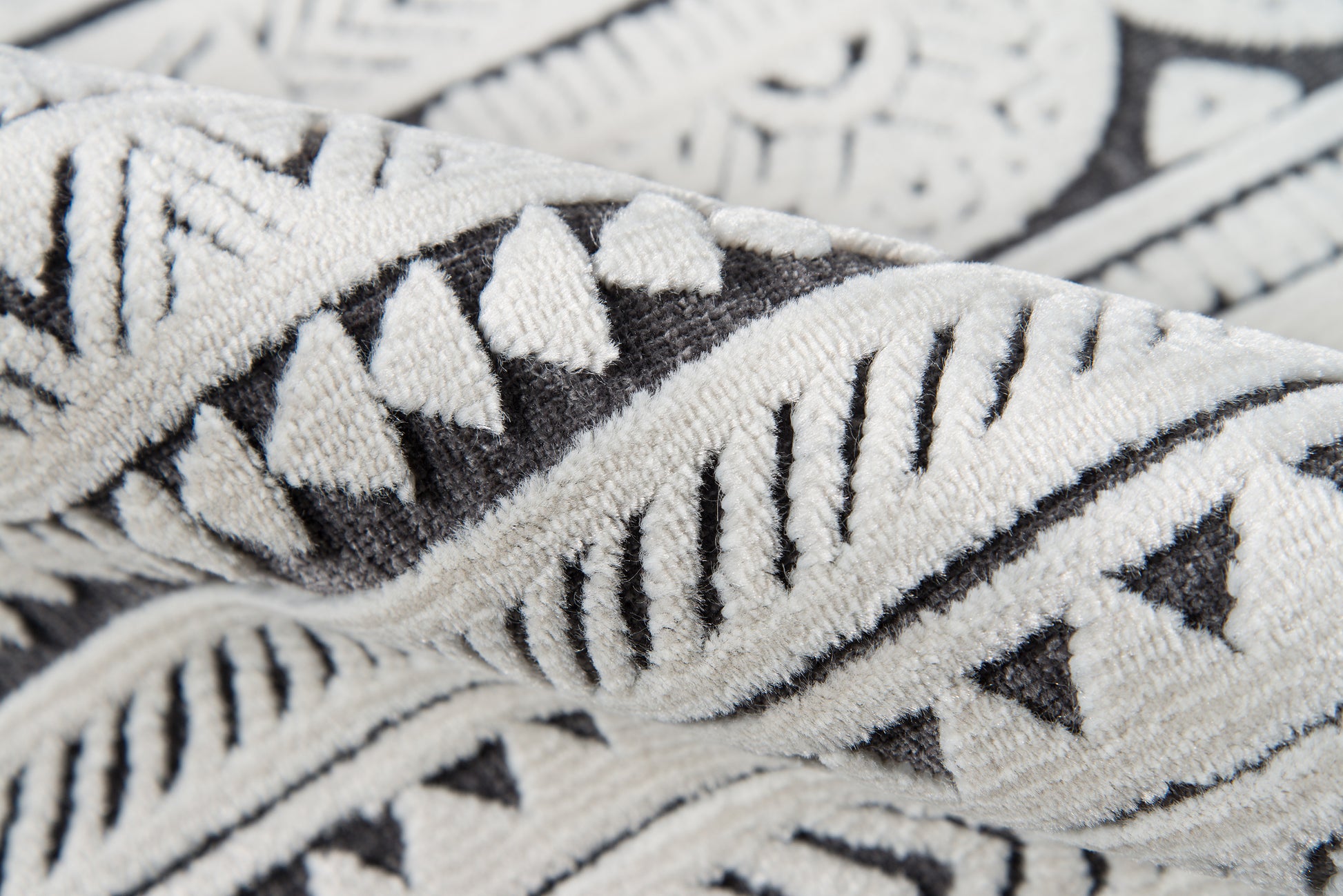 Close-up of a black-and-white geometric patterned throw blanket with a soft woven texture.