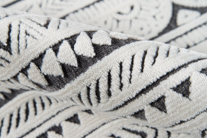 Close-up of a black-and-white geometric patterned throw blanket with a soft woven texture.