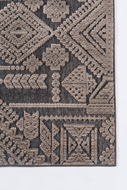 Geometric tribal rug corner in taupe and brown, woven with diamond and floral motifs.