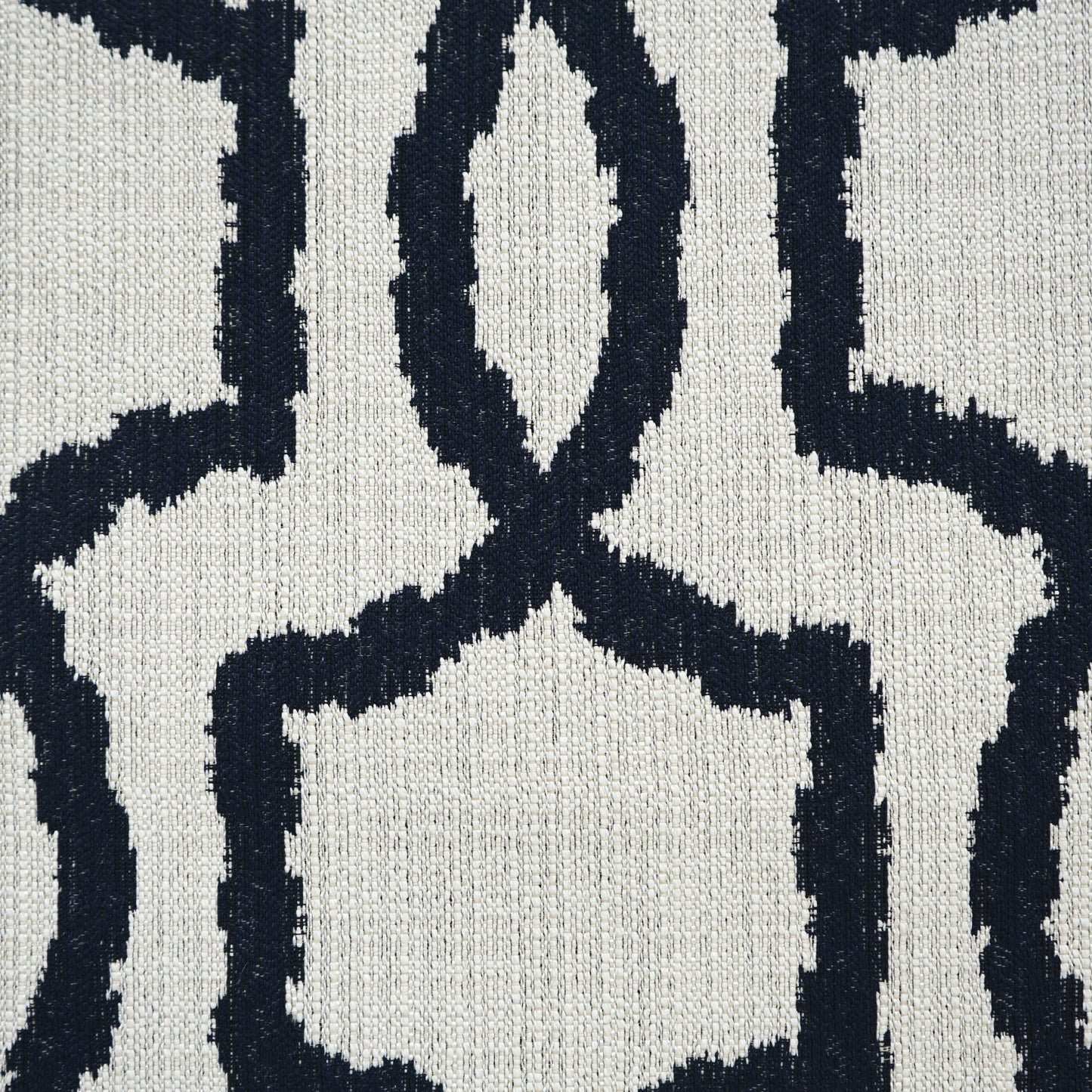 Navy blue geometric lattice fabric on cream background; woven texture and bold interlocking shapes.