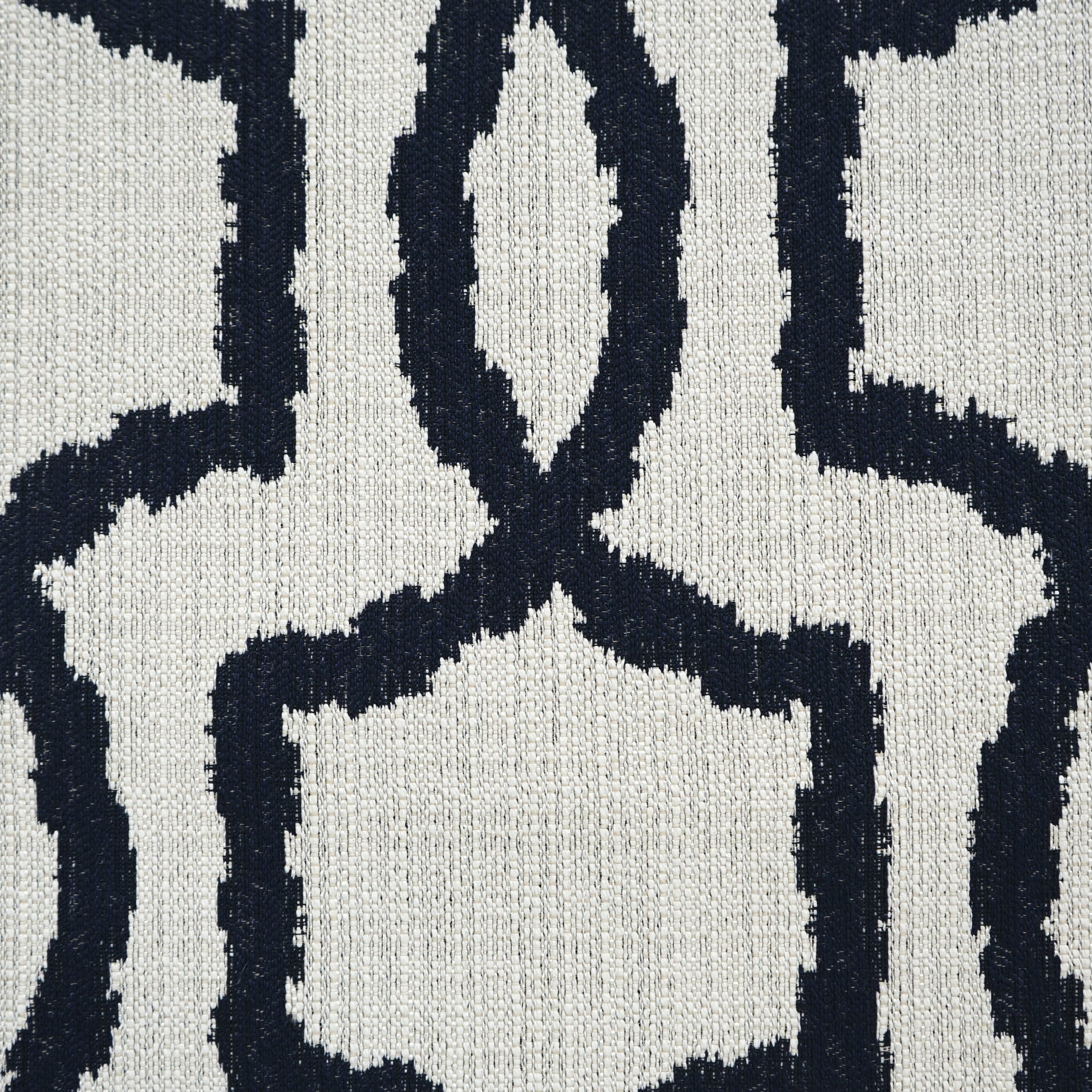 Navy blue geometric lattice fabric on cream background; woven texture and bold interlocking shapes.
