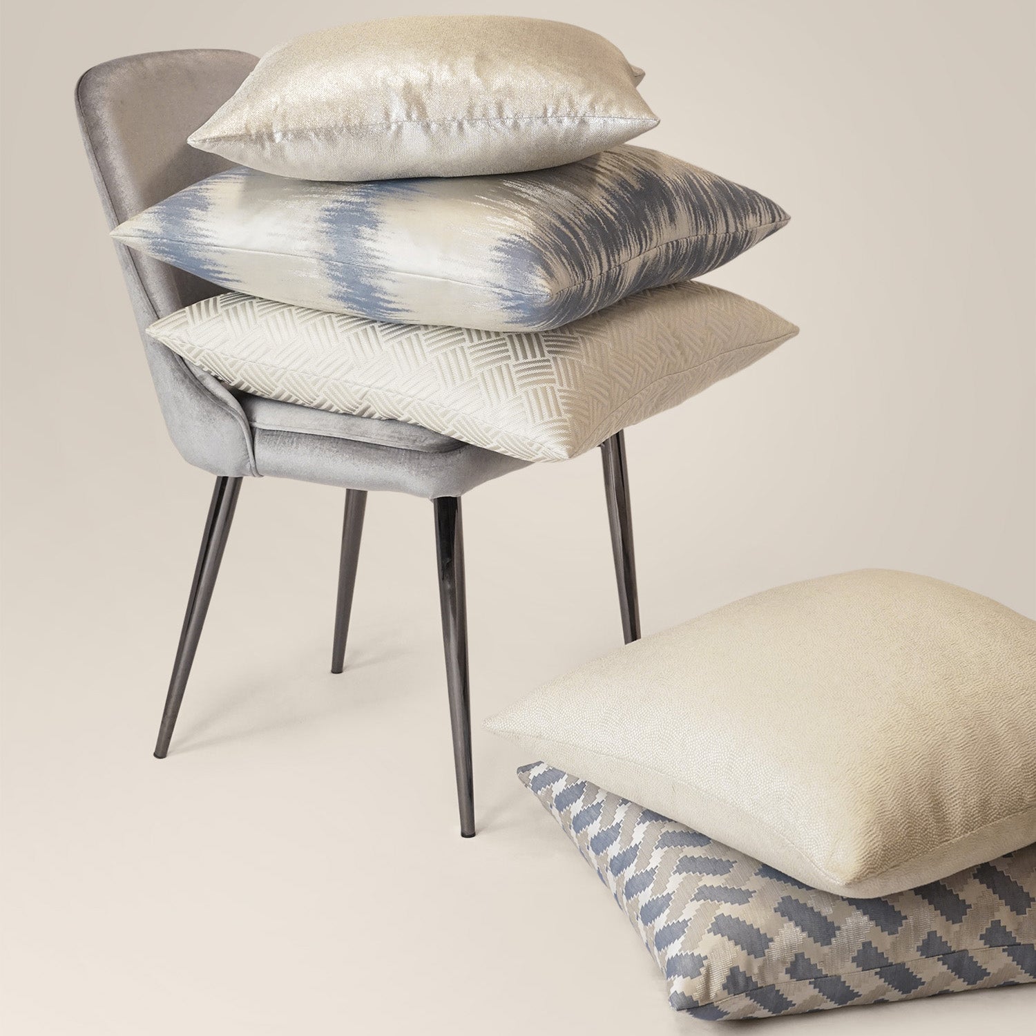 Ivory solid abstract pillow on a gray chair.
