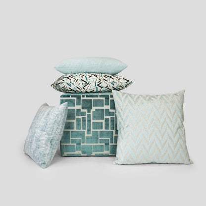 Set of solid teal ripple-textured throw pillows around a teal cube.