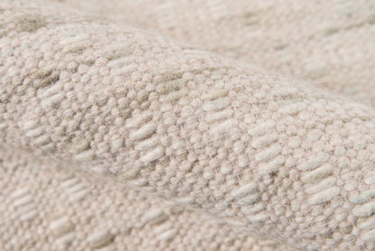 Beige boucle knit rug close-up with raised loop texture; soft, plush material.