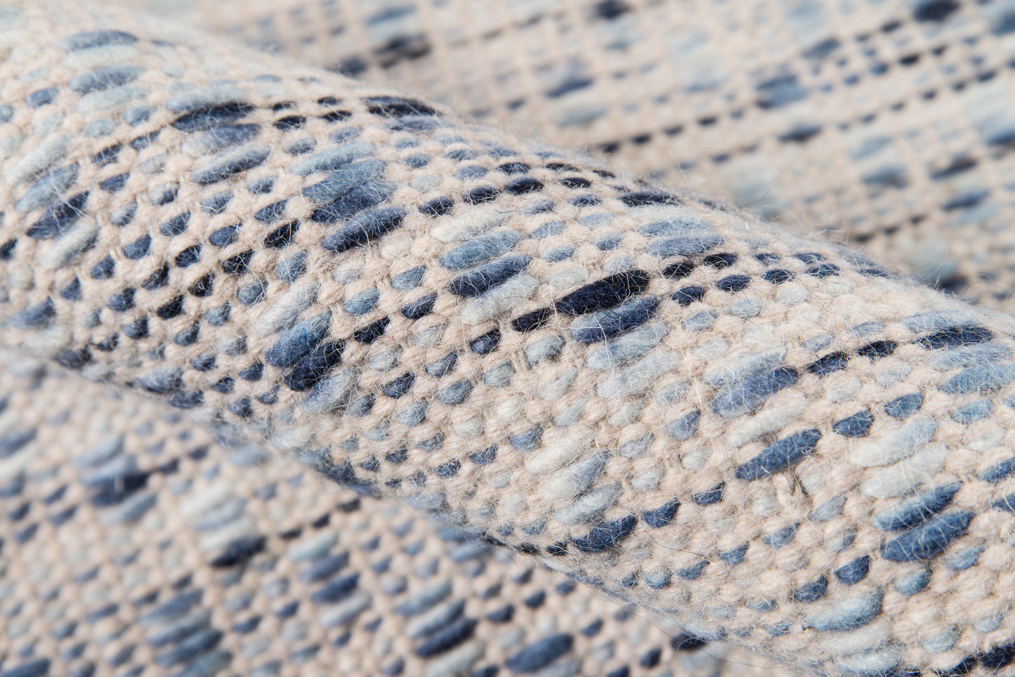 Close-up of blue-and-cream marled fabric with a chunky textured weave on a rug runner.