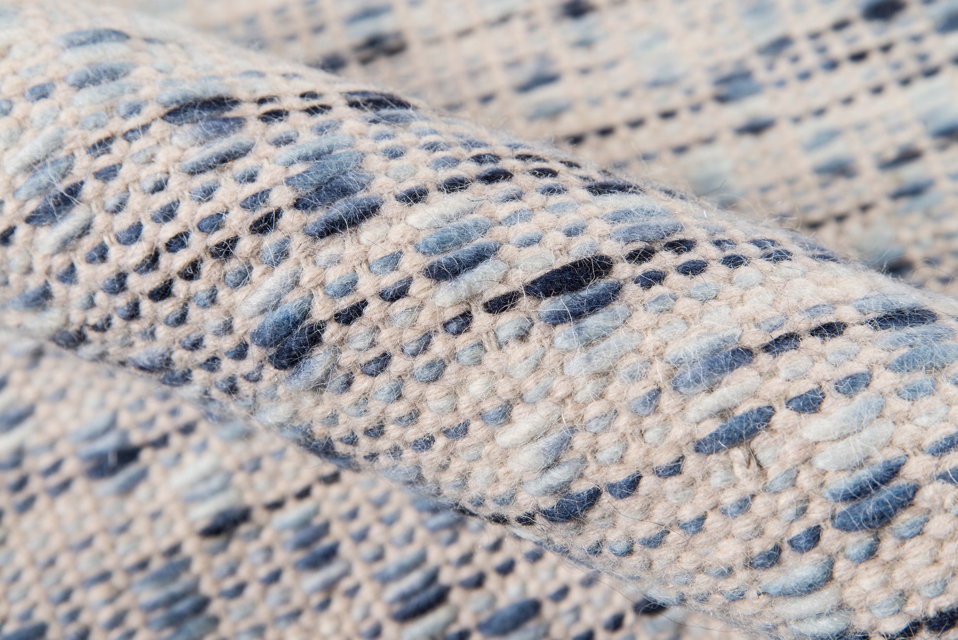 Close-up of blue-and-cream marled fabric with a chunky textured weave on a rug runner.