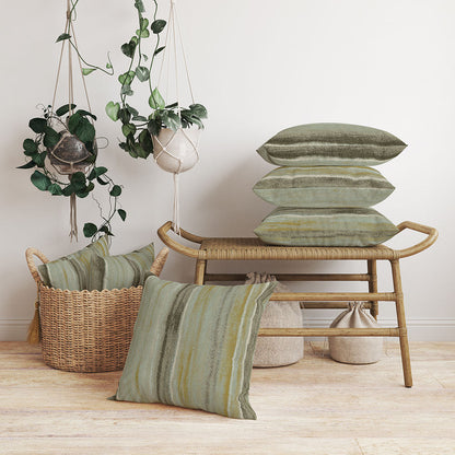 Olive-green striped cushions on a natural rattan bench, with hanging macrame planters and a woven basket of extra pillows.