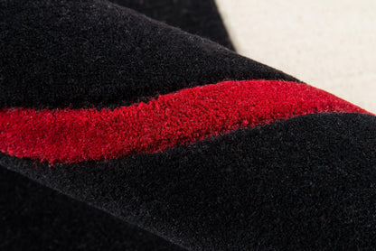 Close-up of black velvet fabric with a bright red textured stripe running diagonally.