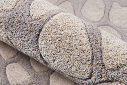 Close-up of a plush shag runner rug in taupe and beige tones, rolled edge, with circular tufted patterns for cozy home decor.