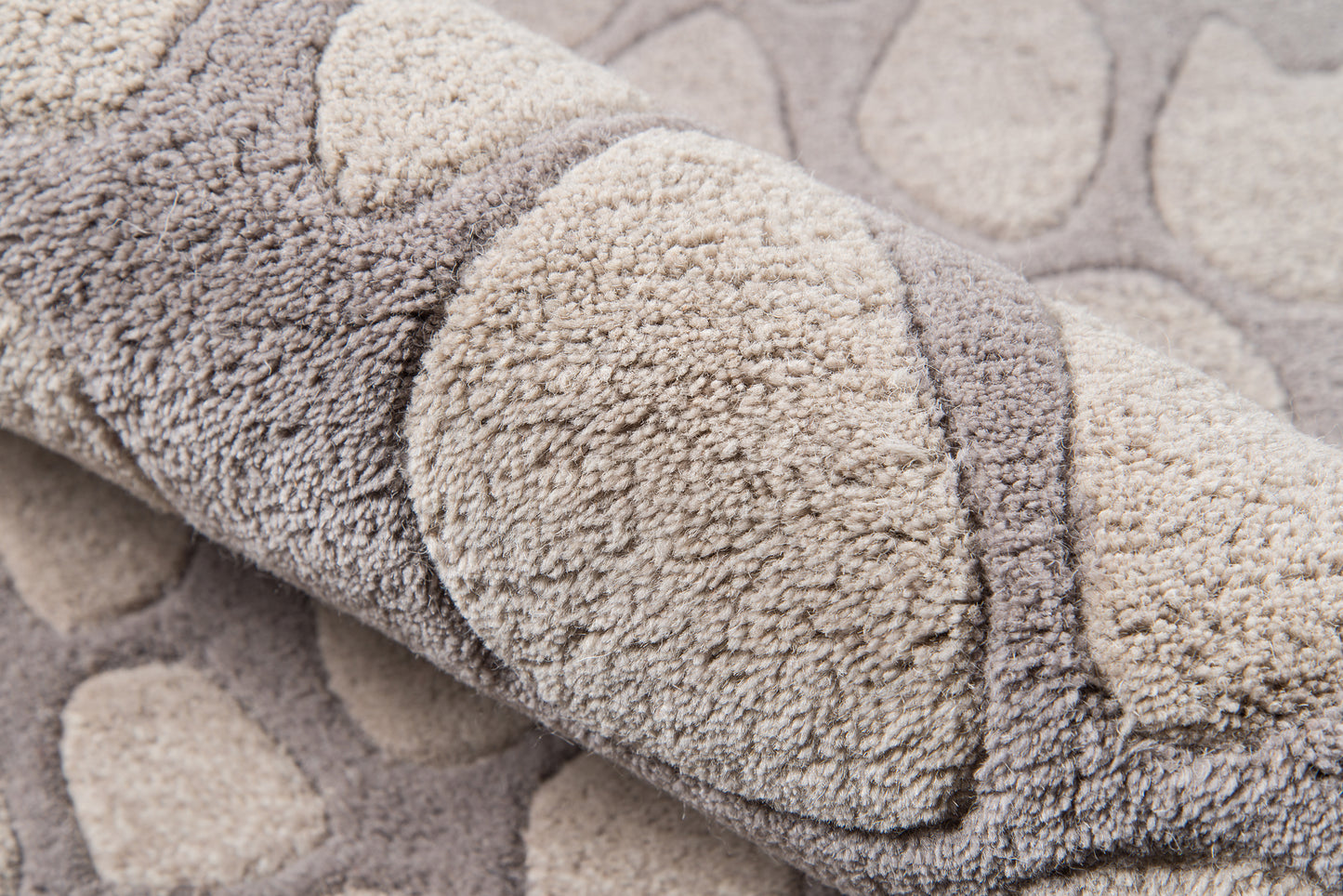 Neutral gray-beige plush shag rug with circular tufted pattern and soft, thick pile.