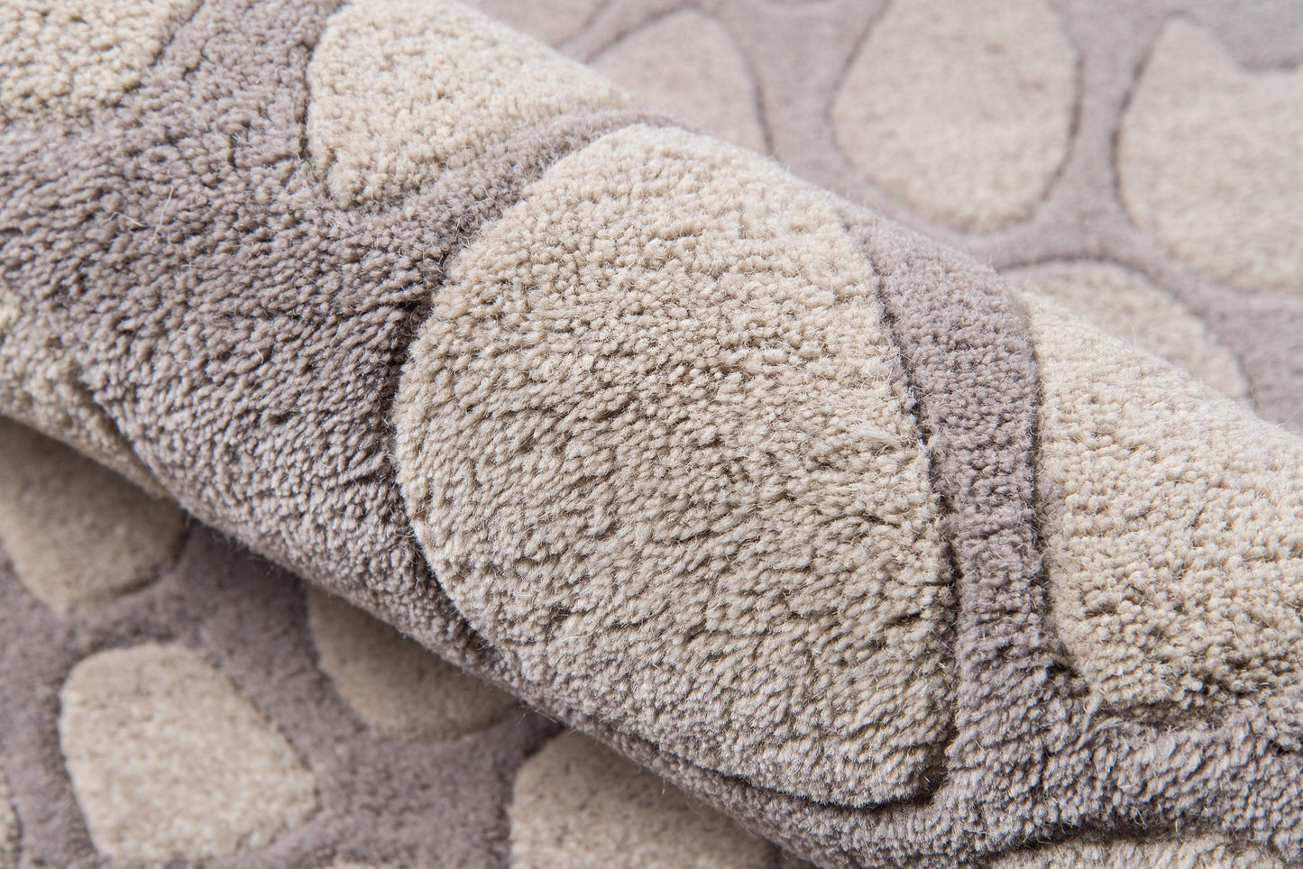 Soft plush rug with taupe and beige pebble pattern, dense loop pile, rolled edge.
